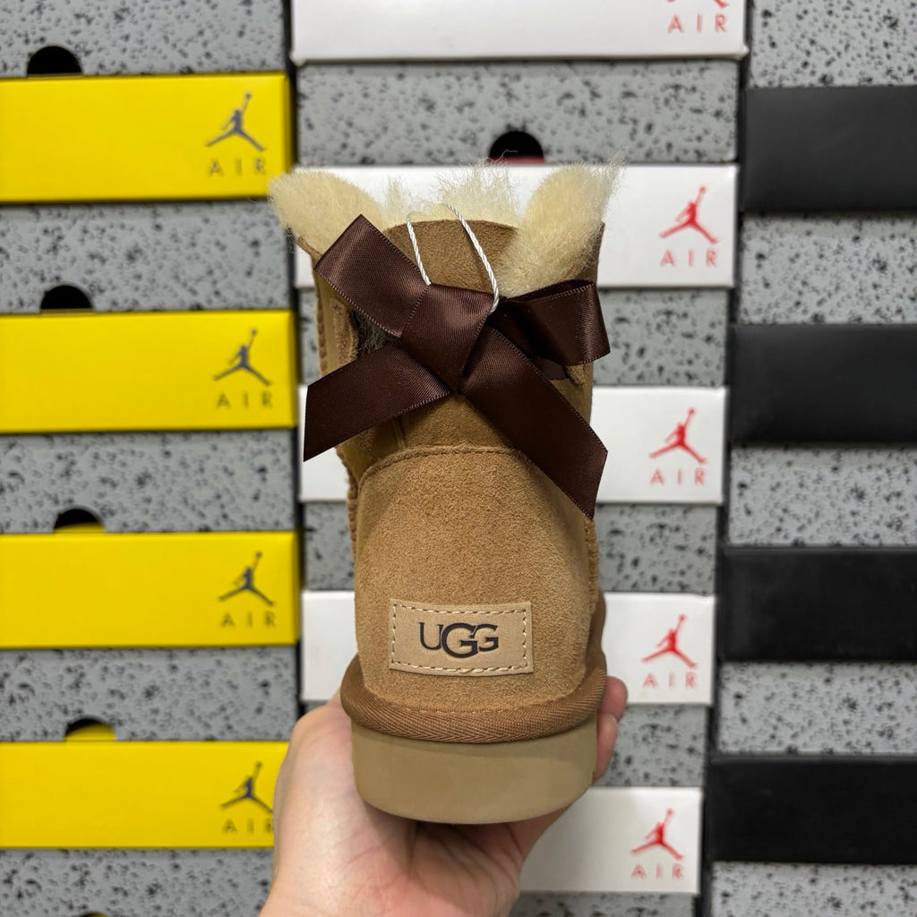 UGG Mini Bailey Bow Ankle Boot – Suede Boot with Cream Shearling Lining, Dark Chocolate Satin Bow & Tan Sugar Sole in Chestnut